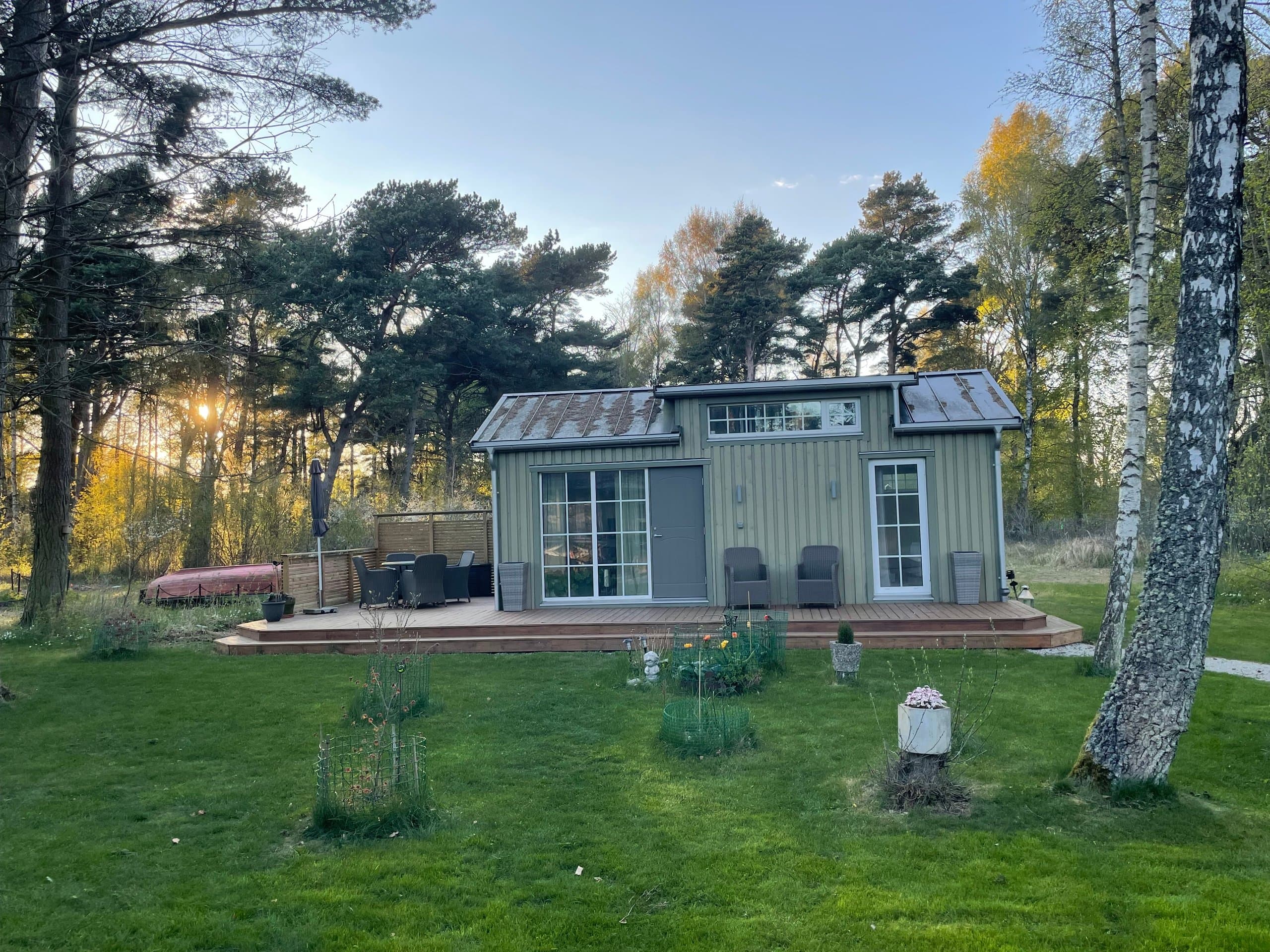 Hamngardi's moderna stuga med vacker utsikt över gröna omgivningar. Rymlig veranda, stora fönster och naturnära läge bland träd. Perfekt för att njuta av lugn och landsbygdsidyll.